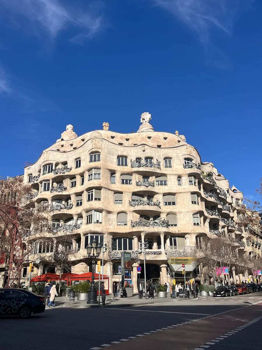 Wavy façade of Gaudí's Casa Milà (La Pedrera) under a blue sky, Barcelona