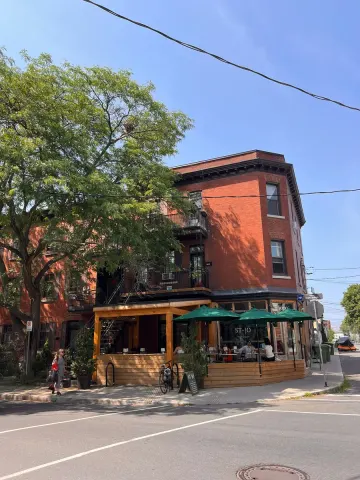 Red-brick building and café terrace with green parasols on the Plateau, Montreal
