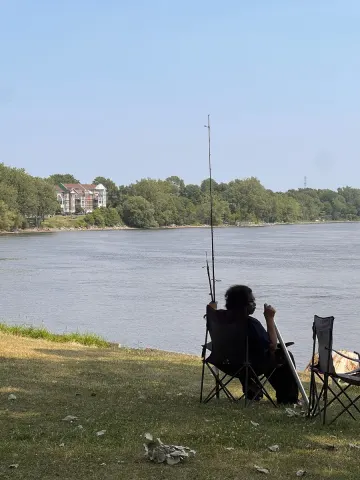 Angler in a folding chair on the bank of the St. Lawrence, Montreal